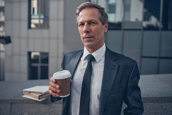 Goed uitziende zakenman die koffie drinkt op straat — Stockfoto