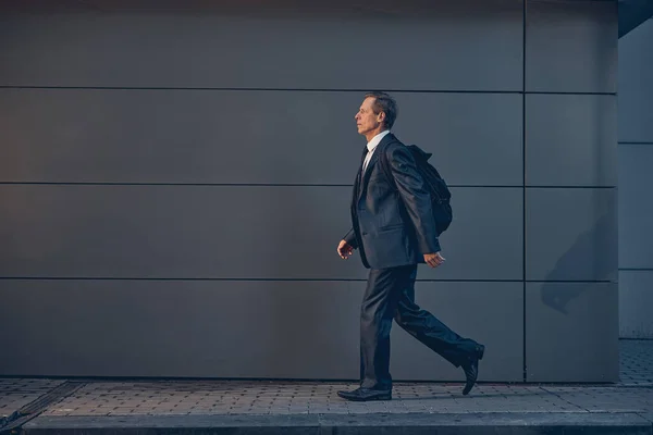 Snygg man med ryggsäck går på gatan — Stockfoto