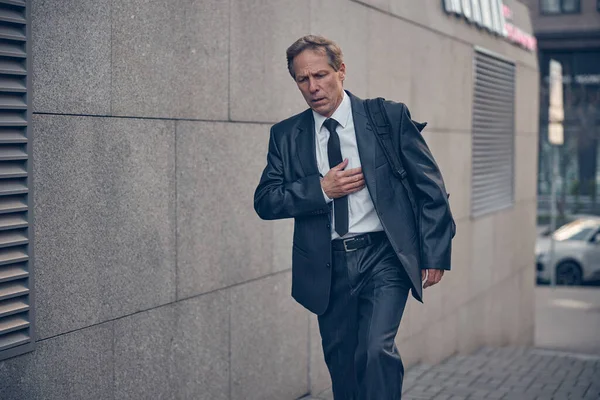 Elegant man feeling pain in heart outdoors — Stock Photo, Image