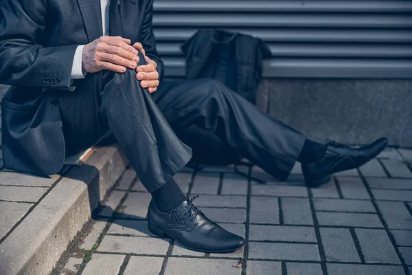 Uomo che soffre di dolore al ginocchio per strada — Foto Stock