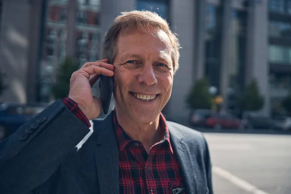 Veselý muž mluví na mobilním telefonu venku — Stock fotografie