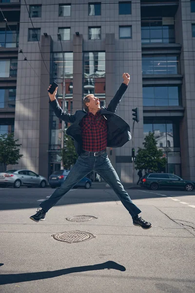 Uomo allegro che salta con gioia per strada — Foto Stock