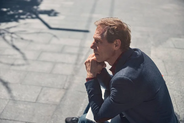 Knappe man zittend op een trap op straat — Stockfoto