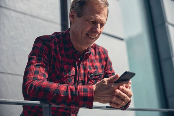 Homem alegre usando telefone celular na rua — Fotografia de Stock