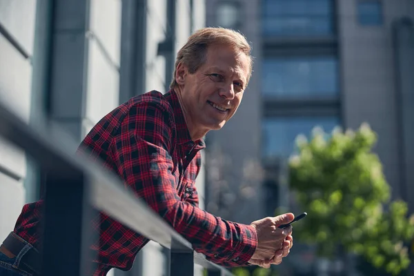 Vrolijke man met mobiele telefoon op straat — Stockfoto