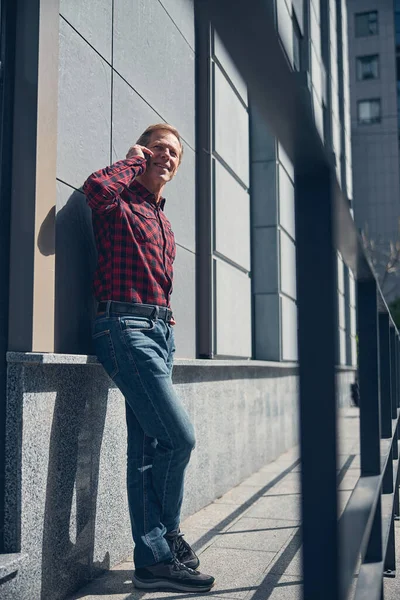Красивый стильный мужчина разговаривает по мобильному телефону на открытом воздухе — стоковое фото