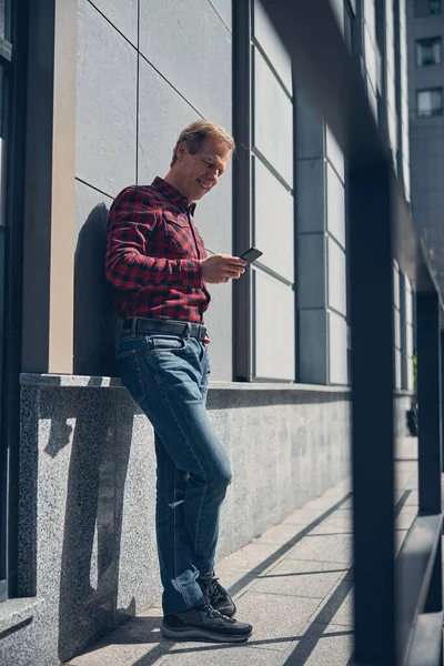 Schöner fröhlicher Mann mit Handy im Freien an sonnigem Tag — Stockfoto