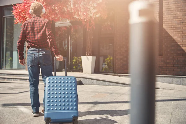 Stilvoller Mann trägt Reisekoffer auf der Straße — Stockfoto