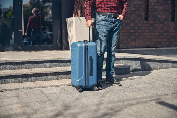 Homem elegante com mala de viagem em pé na rua — Fotografia de Stock