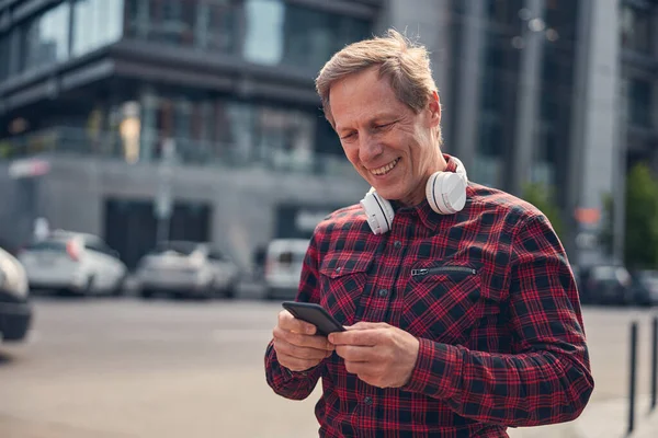 Schöner fröhlicher Mann mit Handy im Freien — Stockfoto