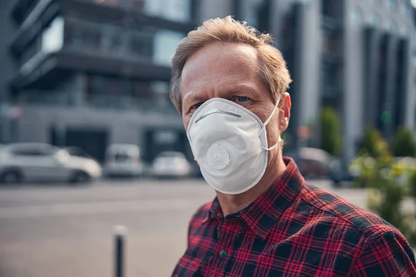 Homem com respirador médico antiviral em pé na rua — Fotografia de Stock