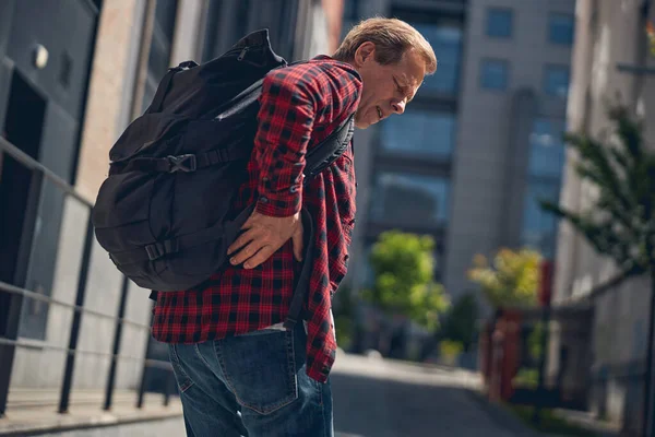 Hombre infeliz sintiendo dolor en la parte baja de la espalda al aire libre —  Fotos de Stock