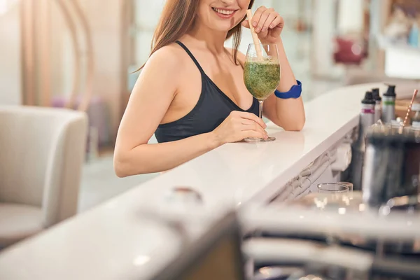 Young spa client sipping a healthy drink — Stock Photo, Image