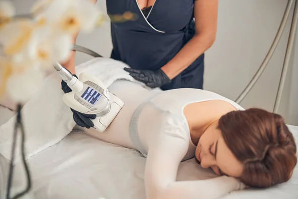 Mujer acostada disfrutando del tiempo durante el procedimiento de cuidado de la piel — Foto de Stock