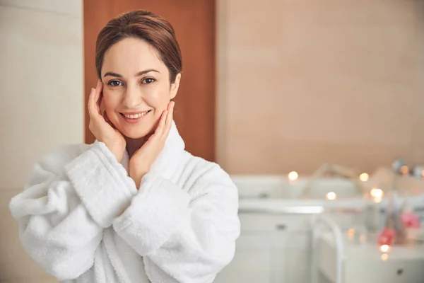 Pretty brunette woman posing at camera in spa salon — Stock Photo, Image