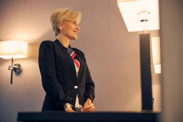 Prachtige vrolijke zakenvrouw staat in hotelkamer — Stockfoto