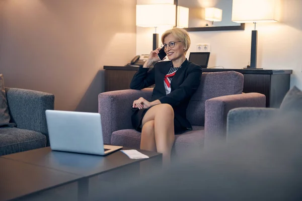 Okouzlující podnikatelka mluví na mobilu v hotelovém pokoji — Stock fotografie