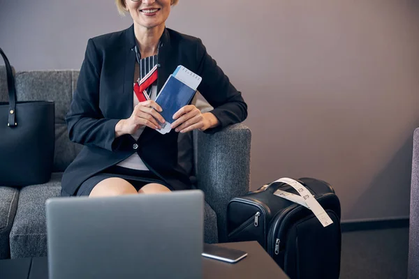 Femme d'affaires joyeuse tenant une carte d'embarquement et souriant — Photo