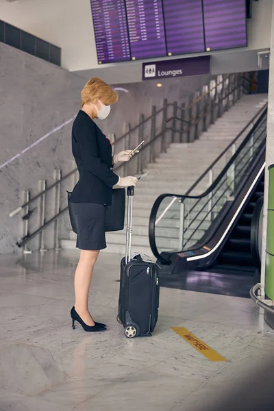 Charmante Geschäftsfrau nutzt Handy am Flughafen — Stockfoto