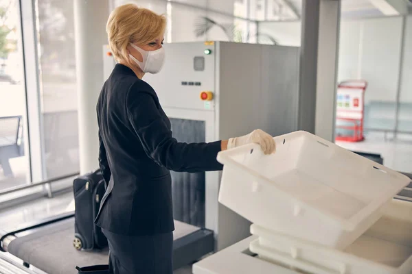 Empresaria encantadora agarrando contenedor para el equipaje en el aeropuerto —  Fotos de Stock