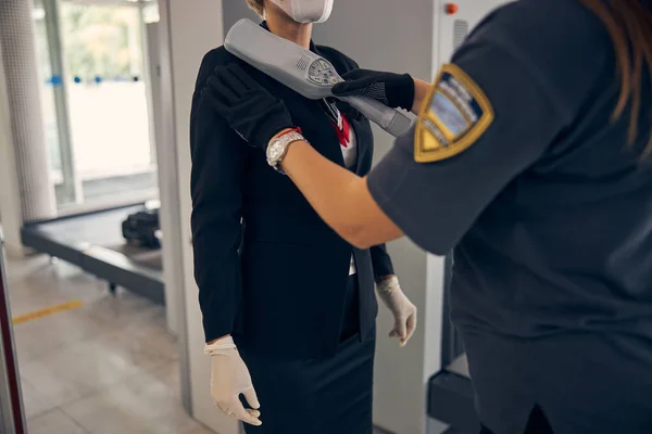 공항 여자 경찰관 금속 탐지기로 여자를 검색하는 모습 — 스톡 사진