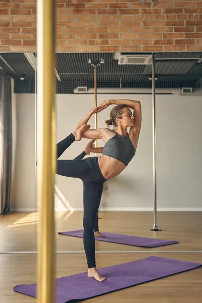 Sportliche junge Frau macht Yoga-Übungen im Studio — Stockfoto