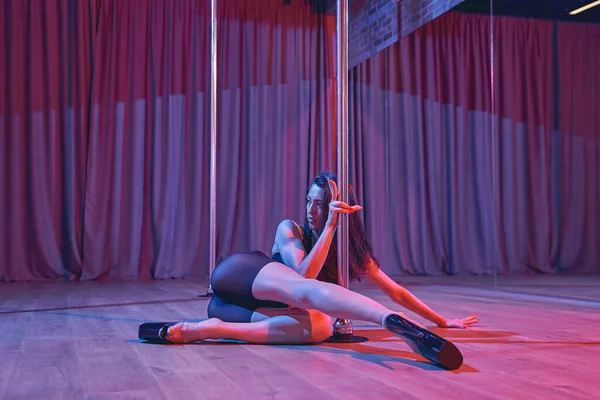 Sexy bailarina haciendo pole dance trick en discoteca —  Fotos de Stock