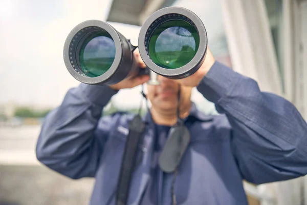 Handsome adult man looking away through binoculars — Stock Photo, Image