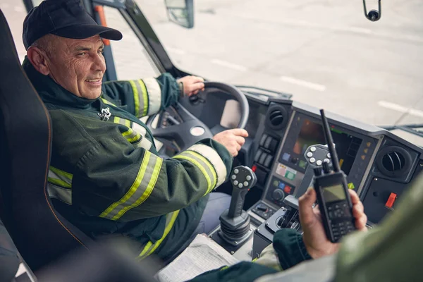 Sorrindo motorista bonito está ouvindo seus colegas — Fotografia de Stock