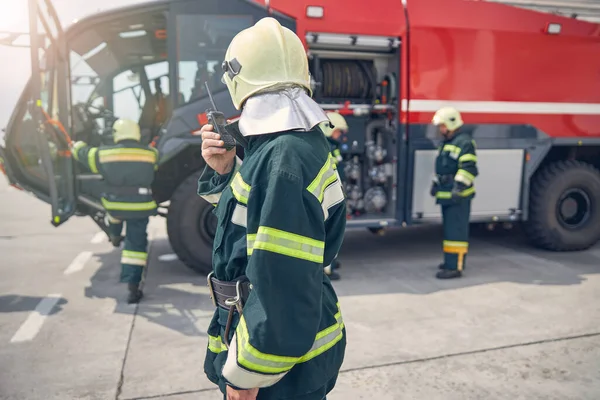 Retrato de homem em capacete amarelo segurando walkie na mão — Fotografia de Stock