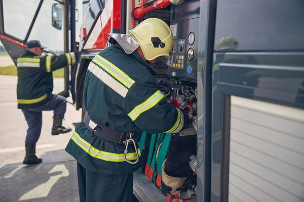 Een man in een brandwerend uniform buiten. — Stockfoto