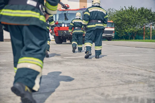 Tre självsäkra män som kör till modern lastbil på brandstationen — Stockfoto