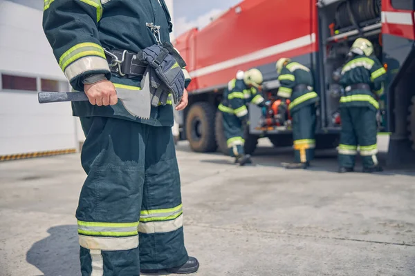 Portret van een sterke man in groen werkuniform met handschoenen aan de riem — Stockfoto