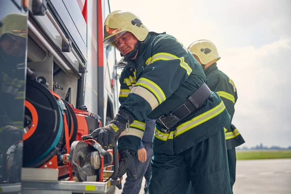 Brandman installera utrustning på brandmaskinen — Stockfoto