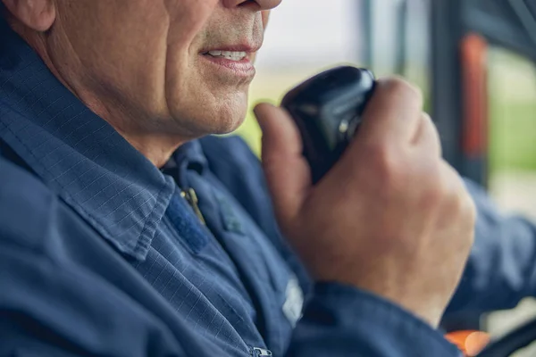 Man håller radio i handen medan man sitter i brandbilen — Stockfoto