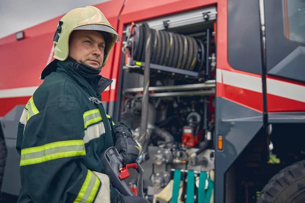 Brandmannen står nära brandbilen. — Stockfoto