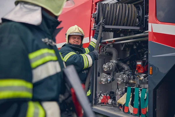 Utbildning av vuxna brandmän med brandutrustning — Stockfoto