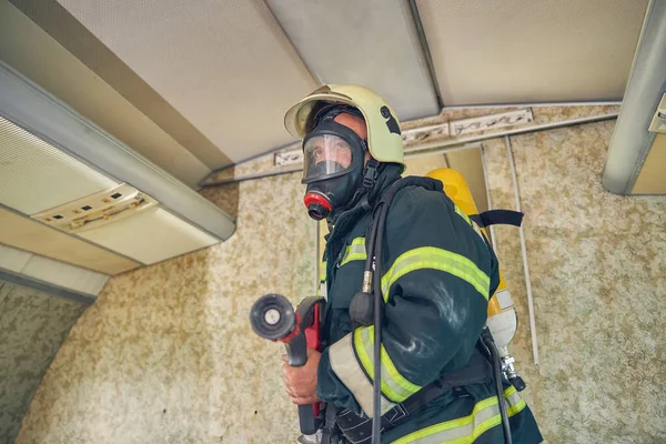 Portret van een brandweerman in uniform en een zuurstofmasker — Stockfoto