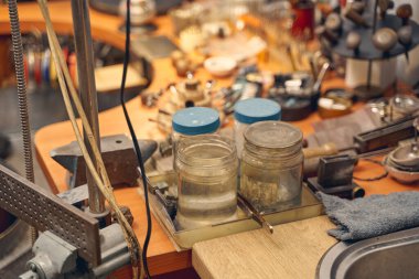 Kuyumcu masasına oyma çözeltisi olan kaplar.