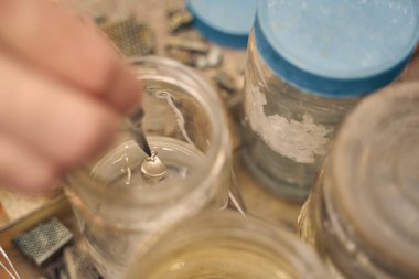 Cımbızla kolye tutan bir kuyumcu.