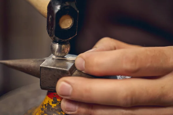 Professional Caucasian artisan using a metalsmithing tool — Stock Photo, Image