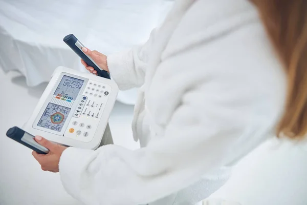 Woman is checking health indicators with body composition analyzed machine — Stock Photo, Image