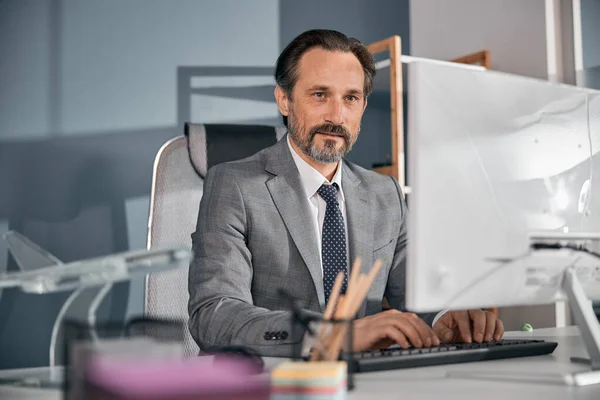 Hombre barbudo guapo usando la computadora en el trabajo — Foto de Stock