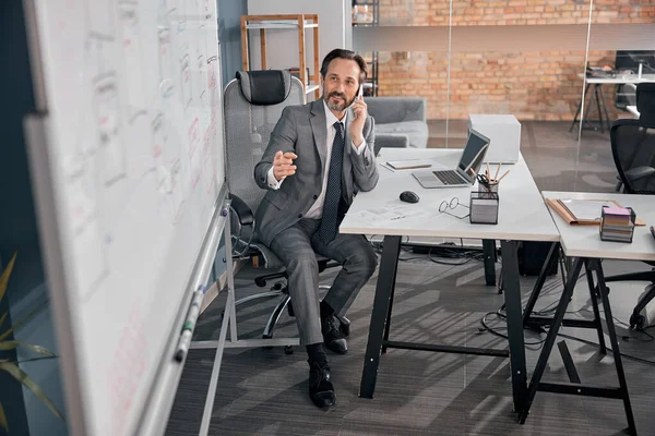 Bonito empresário falando no celular no trabalho — Fotografia de Stock