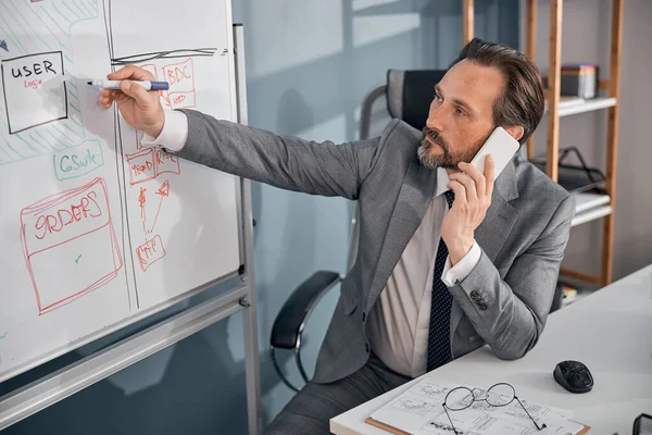 Красивий бізнесмен говорить на мобільному телефоні на роботі — стокове фото
