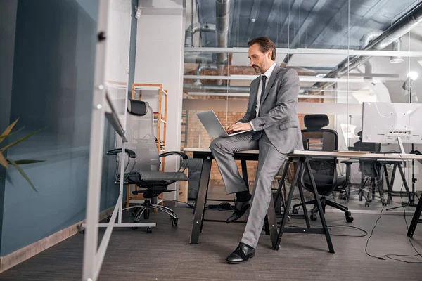 Homem de negócios elegante usando laptop moderno no trabalho — Fotografia de Stock