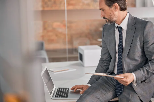 Hombre barbudo guapo usando cuaderno en el trabajo — Foto de Stock