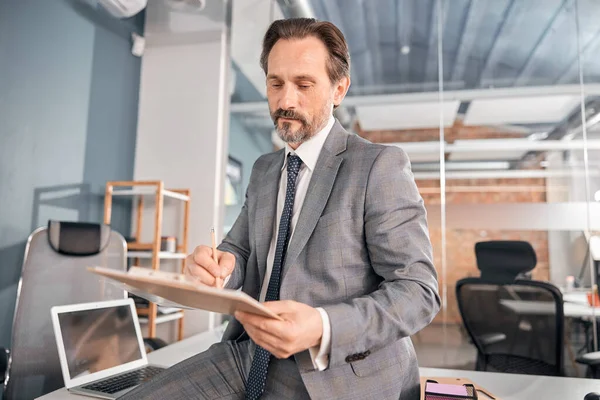 Hombre guapo trabajador estudiando documentos en la oficina — Foto de Stock