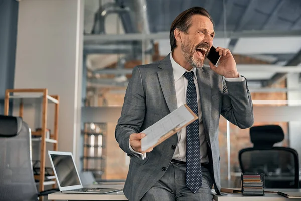 Emocionado hombre de negocios hablando en el teléfono móvil en el trabajo — Foto de Stock