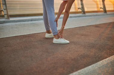 Esnek, sportif bir kadın öne doğru eğiliyor.